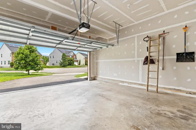 a front view of a house with a garden and trees