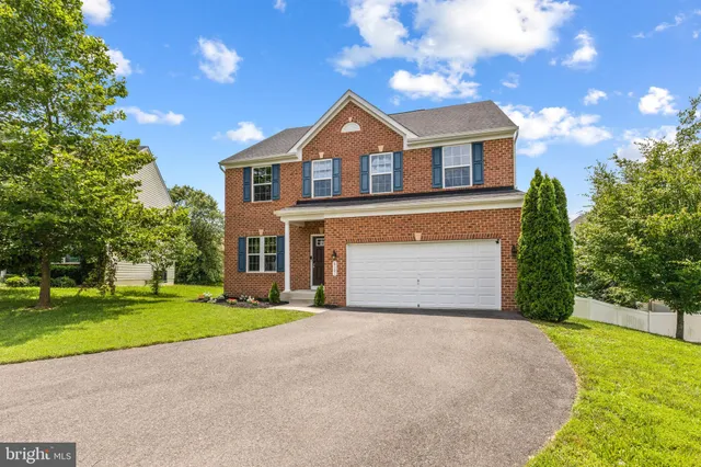 a front view of a house with a garden and yard