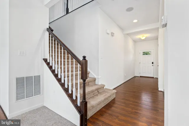 a view of a hallway with wooden floor and staircase