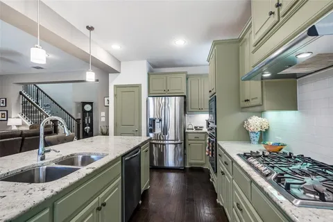 a kitchen with stainless steel appliances granite countertop a sink and a stove