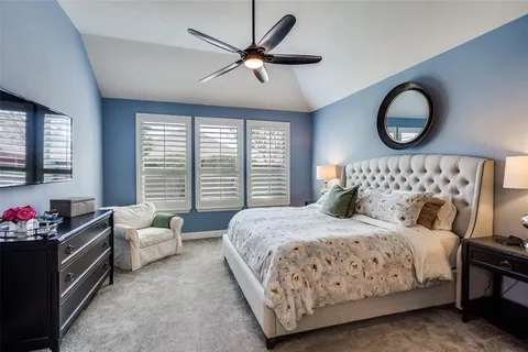 a bedroom with a bed mirror and window