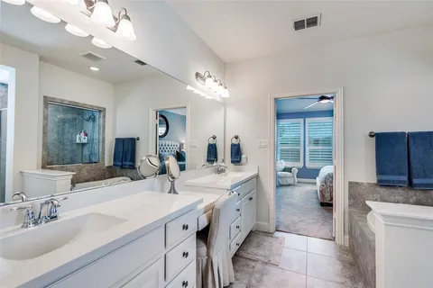 a spacious bathroom with a double vanity sink toilet and a mirror