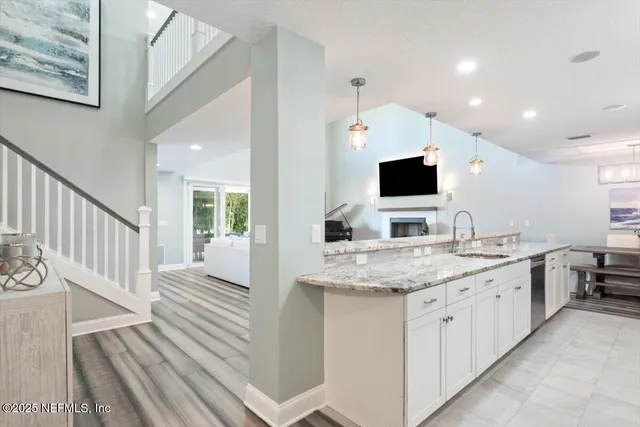 a kitchen with stainless steel appliances kitchen island granite countertop a stove refrigerator and cabinets