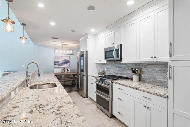 a view of a dining room with furniture and a chandelier