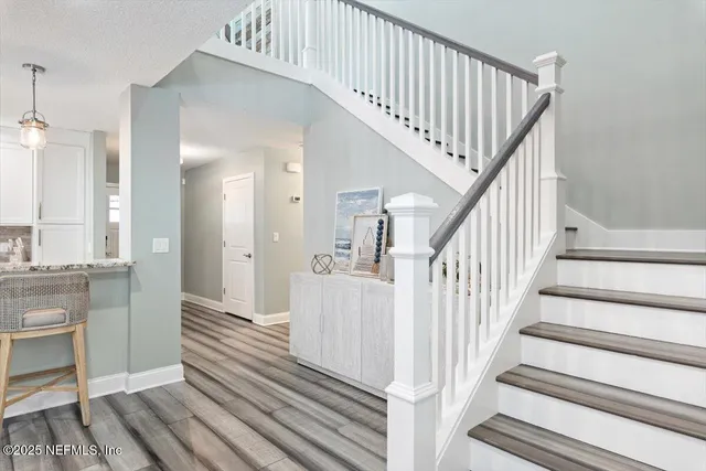 a kitchen with granite countertop a sink stainless steel appliances and white cabinets