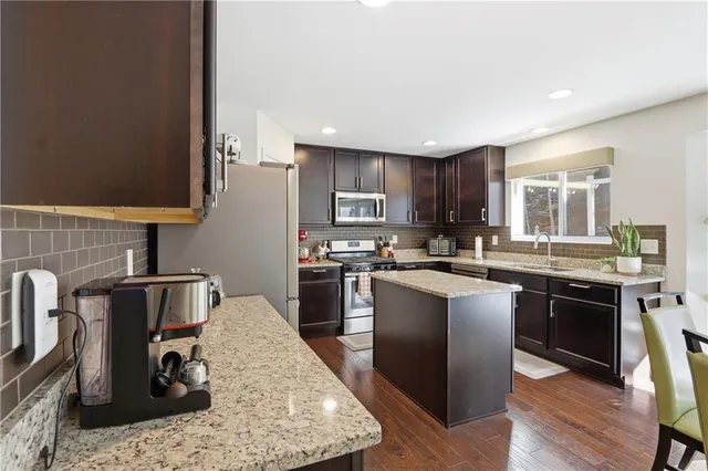 a kitchen with stainless steel appliances granite countertop a sink stove and refrigerator