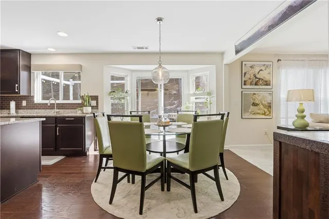 a dining room with furniture a chandelier and wooden floor