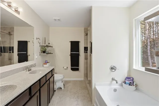 a bathroom with a tub sink and mirror