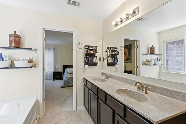 a en suite bathroom with a double vanity sink a mirror and shower
