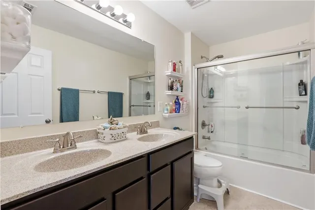 a bathroom with a granite countertop sink toilet mirror and shower