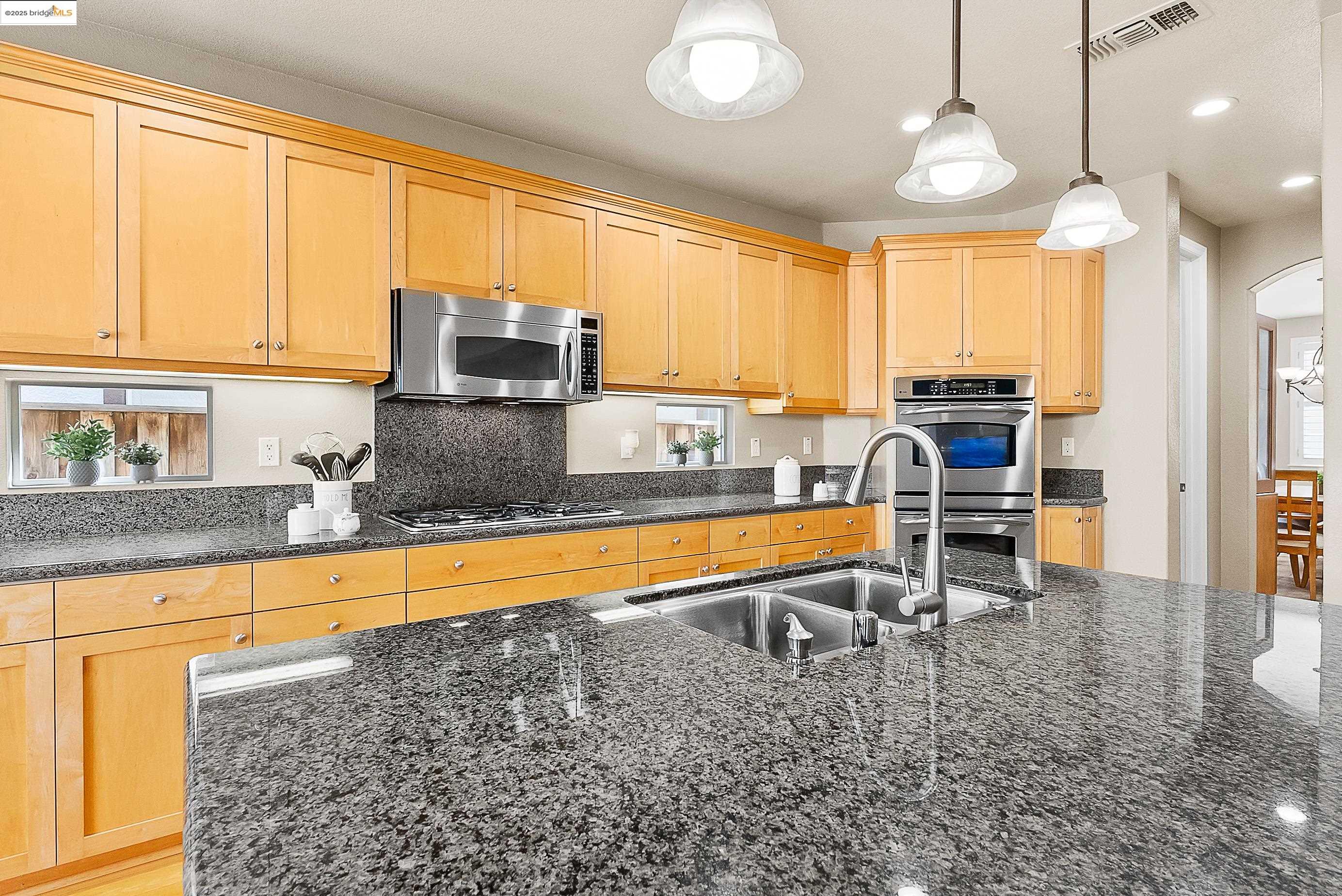 5282 Fern Ridge Circle Discovery Bay, CA 94505 - Photo 12 of 41 a kitchen with stainless steel appliances granite countertop a stove top oven a sink dishwasher a dining table and chairs with wooden floor