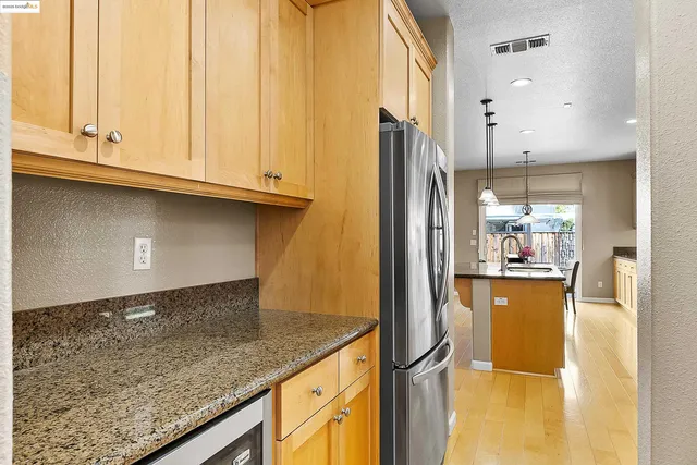 a kitchen with stainless steel appliances granite countertop a refrigerator and a sink