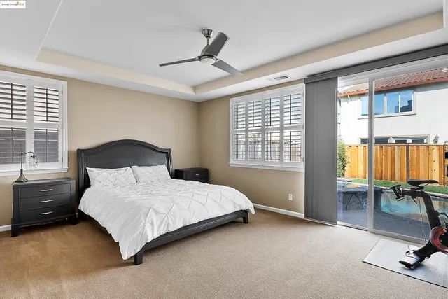 a bedroom with a bed a table and painting on the wall