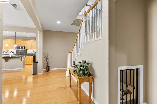a view of a hallway view with wooden floor and a living room