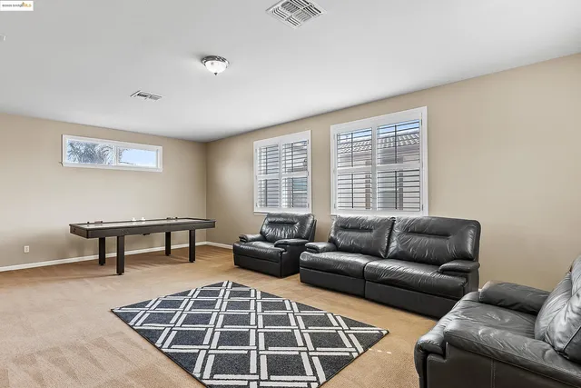 a living room with furniture a rug and a window