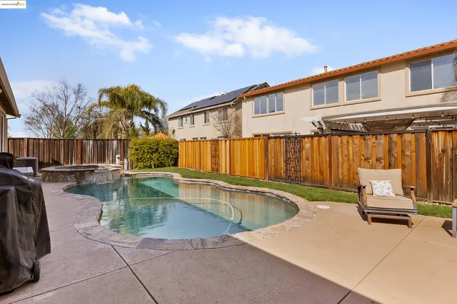 a view of a house with swimming pool and sitting area
