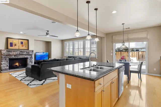 a kitchen with kitchen island a stove a sink a dining table and chairs