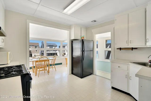 a kitchen with stainless steel appliances kitchen island granite countertop a refrigerator a sink a stove and white cabinets