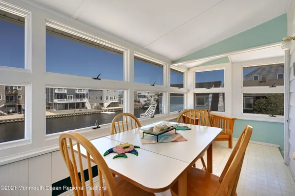 a view of a dining room with furniture a kitchen and chandelier