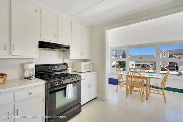 a kitchen with stainless steel appliances a white table and chairs in it