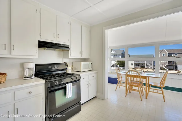 a kitchen with stainless steel appliances a white table and chairs in it