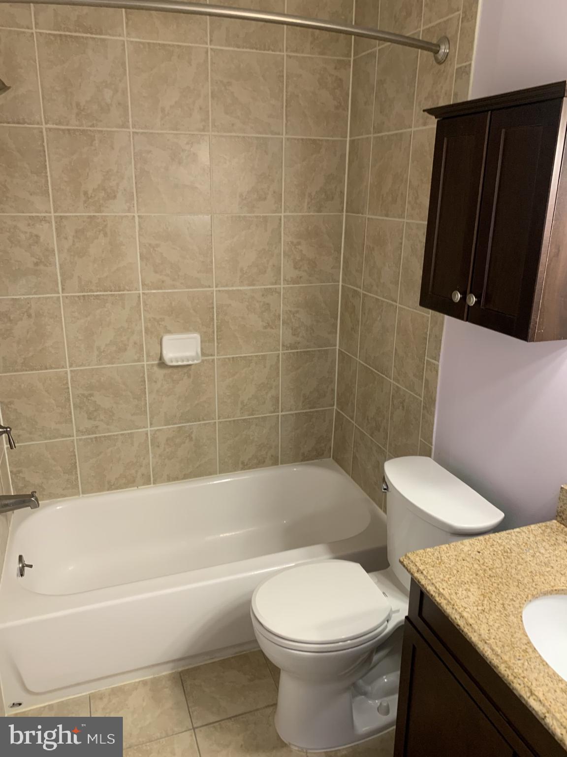 7004 Fitzpatrick Drive Laurel, MD 20707 - Photo 23 of 35 a bathroom with a granite countertop toilet sink and bathtub