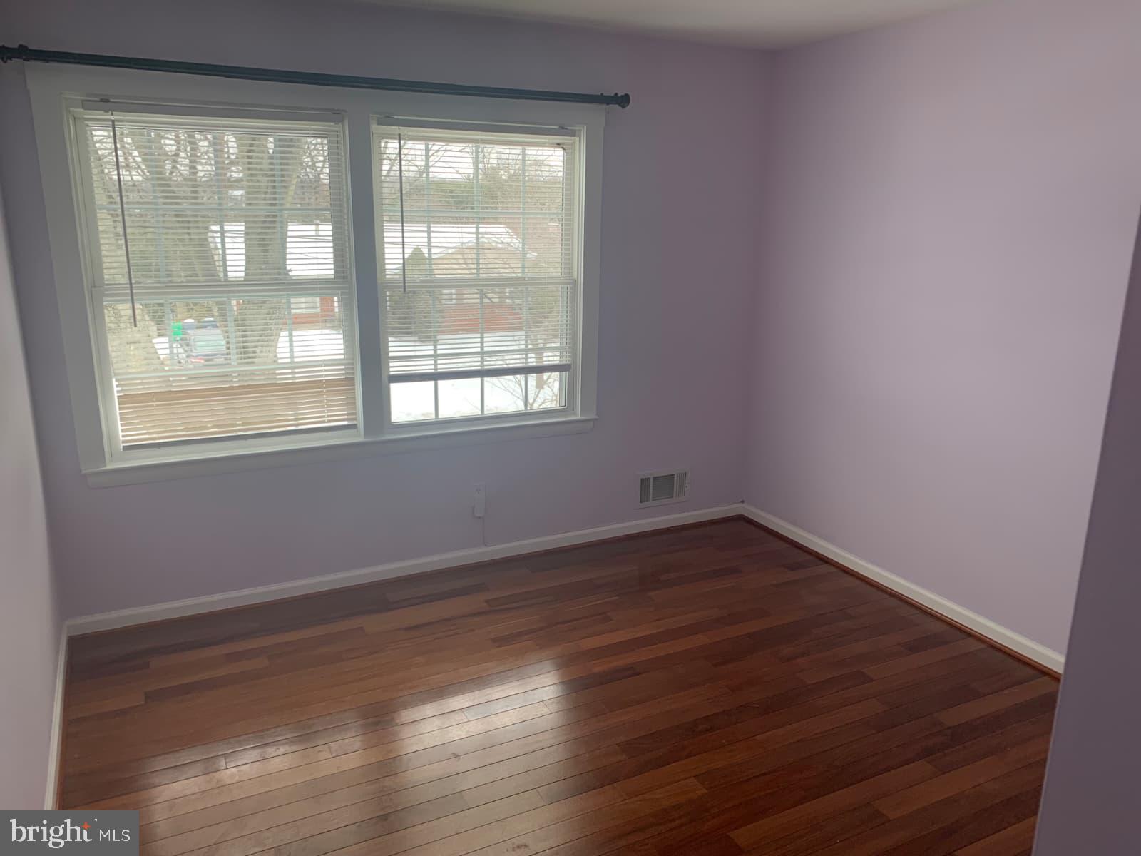 7004 Fitzpatrick Drive Laurel, MD 20707 - Photo 24 of 35 a view of an empty room with wooden floor and a window