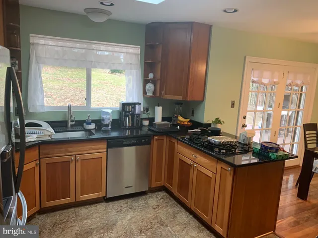 a kitchen with stainless steel appliances granite countertop sink stove top oven and cabinets