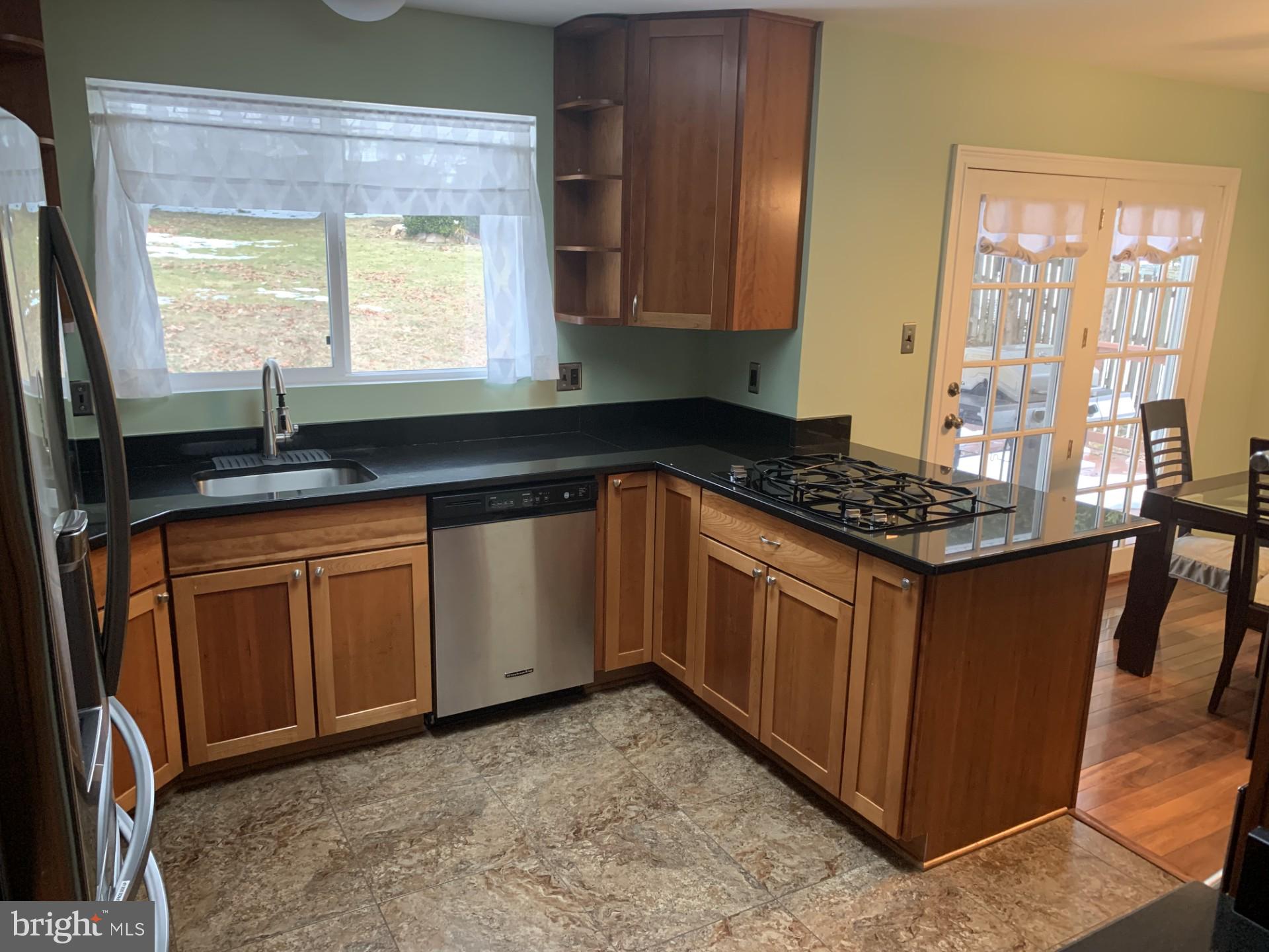 7004 Fitzpatrick Drive Laurel, MD 20707 - Photo 7 of 35 a kitchen with granite countertop a sink stove and cabinets