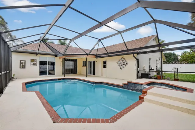 a view of a house with pool and a yard