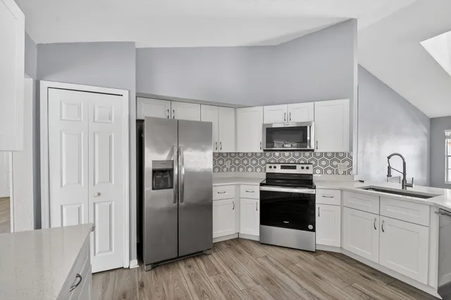 a kitchen with stainless steel appliances a stove a sink and a refrigerator