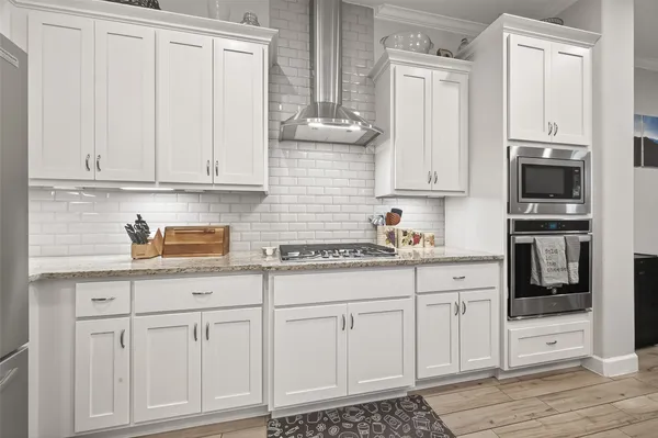 a kitchen with white cabinets and sink