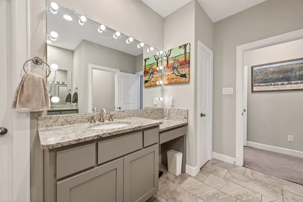 a bathroom with a granite countertop sink a mirror and a shower