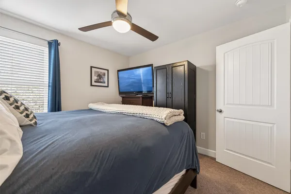 a bedroom with a large bed and a chandelier