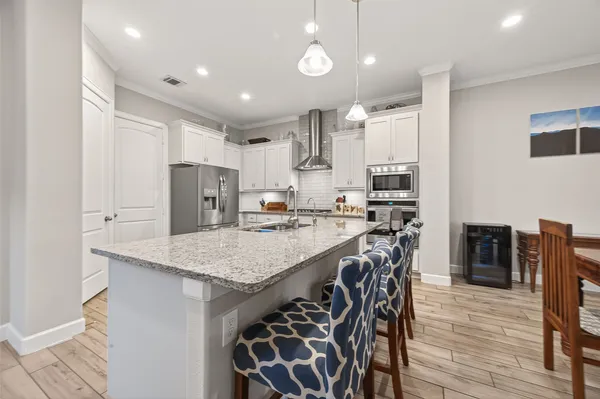 a kitchen with stainless steel appliances granite countertop a sink refrigerator and cabinets