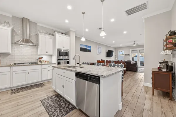 a kitchen with stainless steel appliances kitchen island granite countertop a sink and cabinets