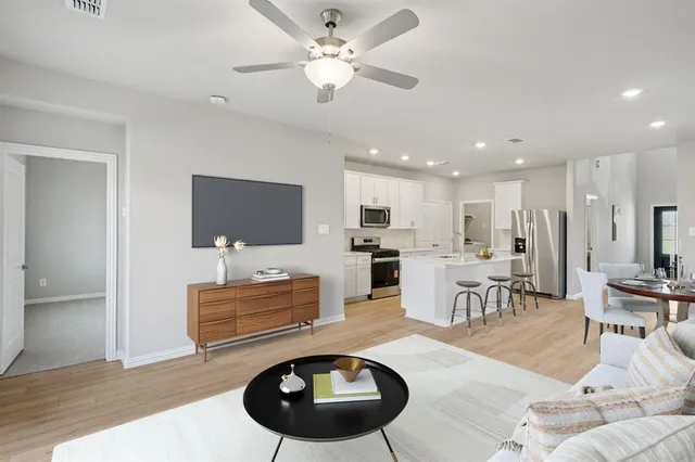 a living room with furniture kitchen view and a chandelier