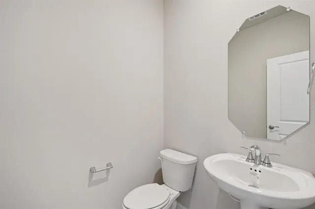 a bathroom with a sink mirror and toilet