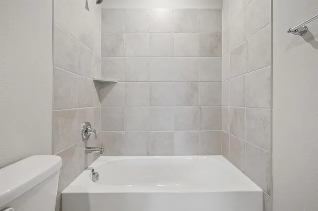 a white bath tub sitting next to a white toilet