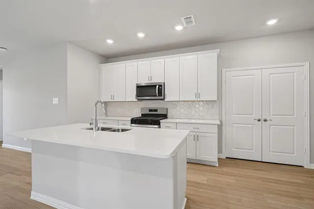 a kitchen with a sink a stove a microwave and cabinets