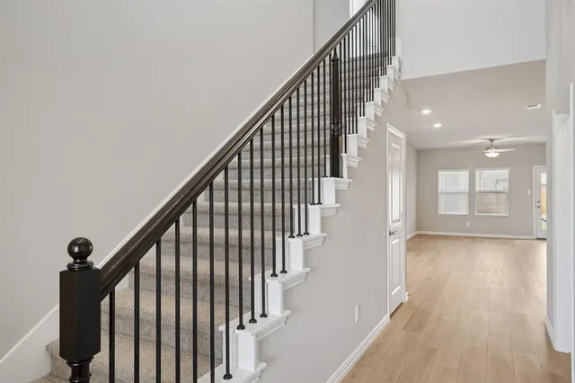 a view of staircase with wooden floor and white walls