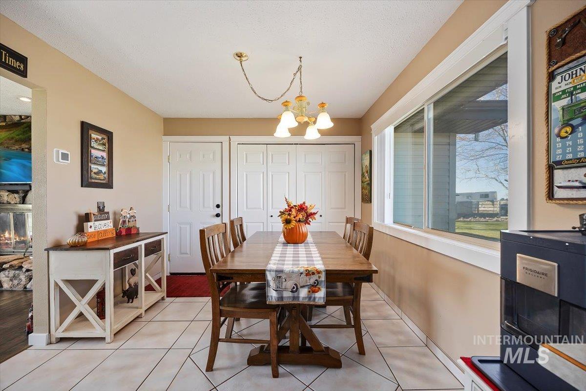 411 Mountain View Lane Burley, ID 83318 - Photo 11 of 38 Dining room featuring light tile patterned floors, a chandelier, and a textured ceiling