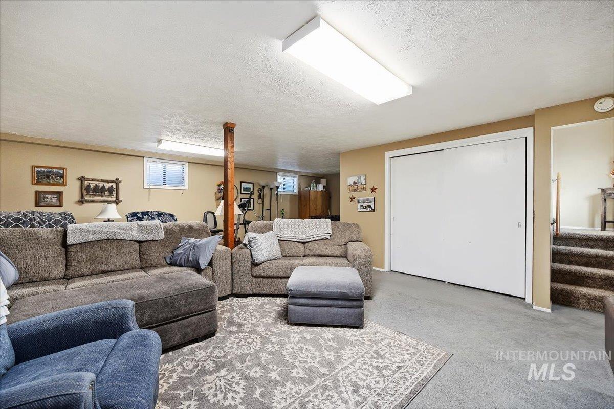 411 Mountain View Lane Burley, ID 83318 - Photo 28 of 38 Living area with a textured ceiling, carpet flooring, and stairway