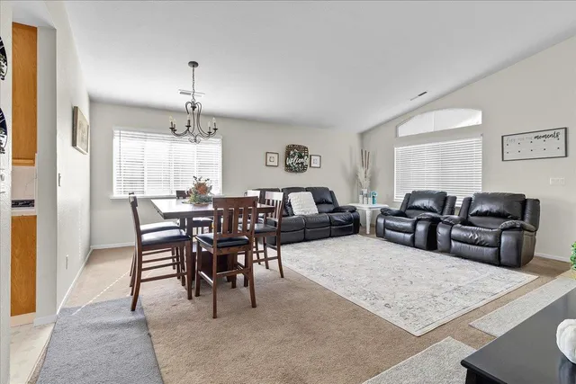 a living room with furniture a chandelier and a dining table