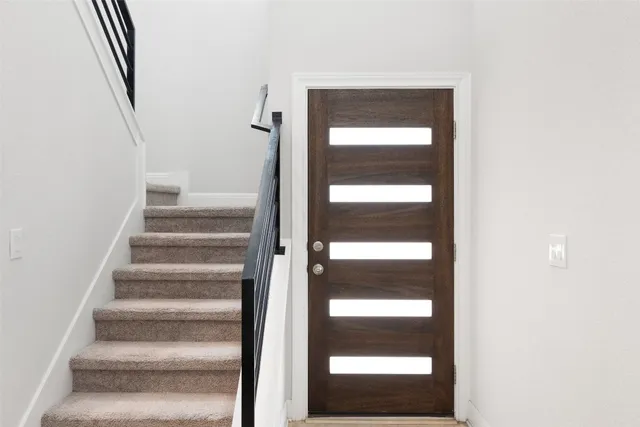 a view of staircase with white walls and a window