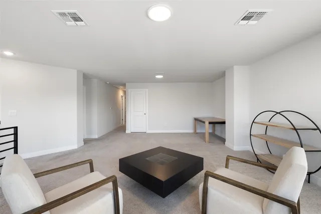 a living room with furniture and a view of kitchen