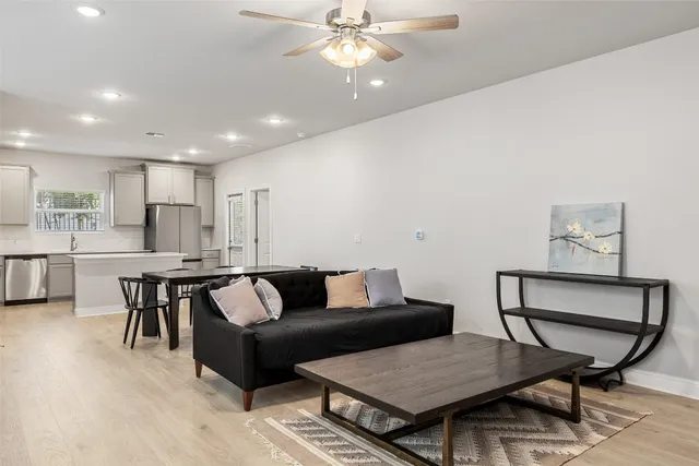 a living room with furniture and a wooden floor