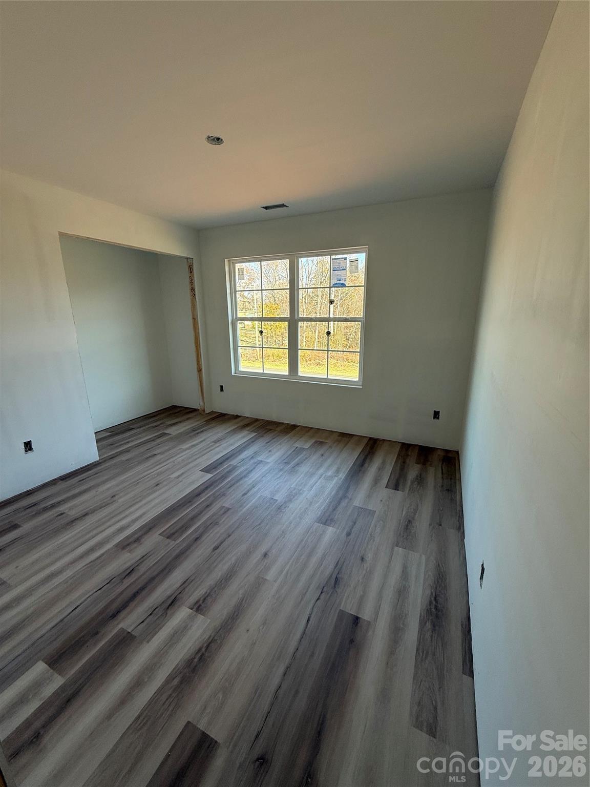 4269 Love Mill Road Stanfield, NC 28163 - Photo 8 of 12 an empty room with wooden floor and windows