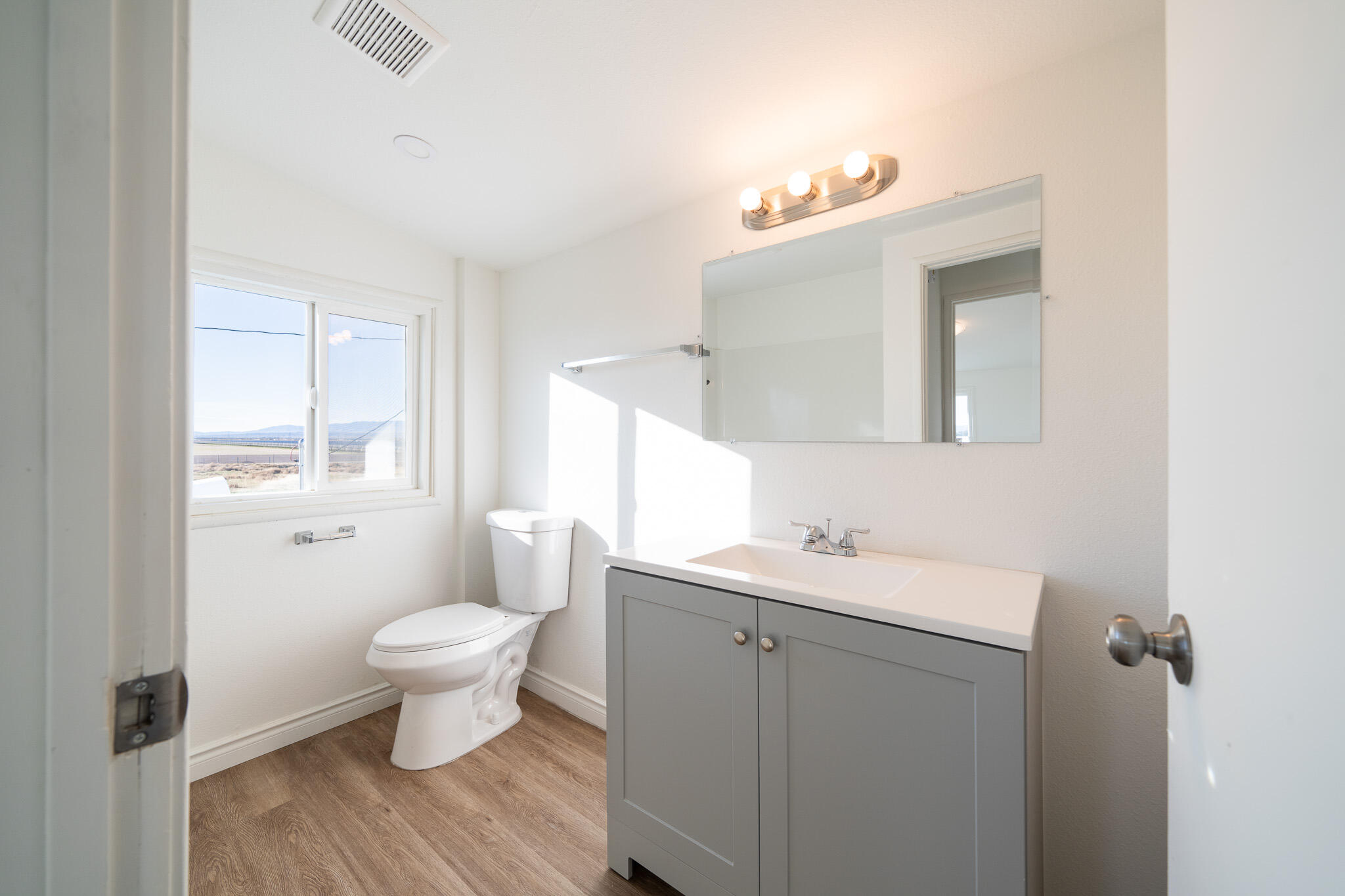 8443 Gaskell Road Rosamond, CA 93560 - Photo 31 of 45 a bathroom with a sink toilet a mirror and vanity