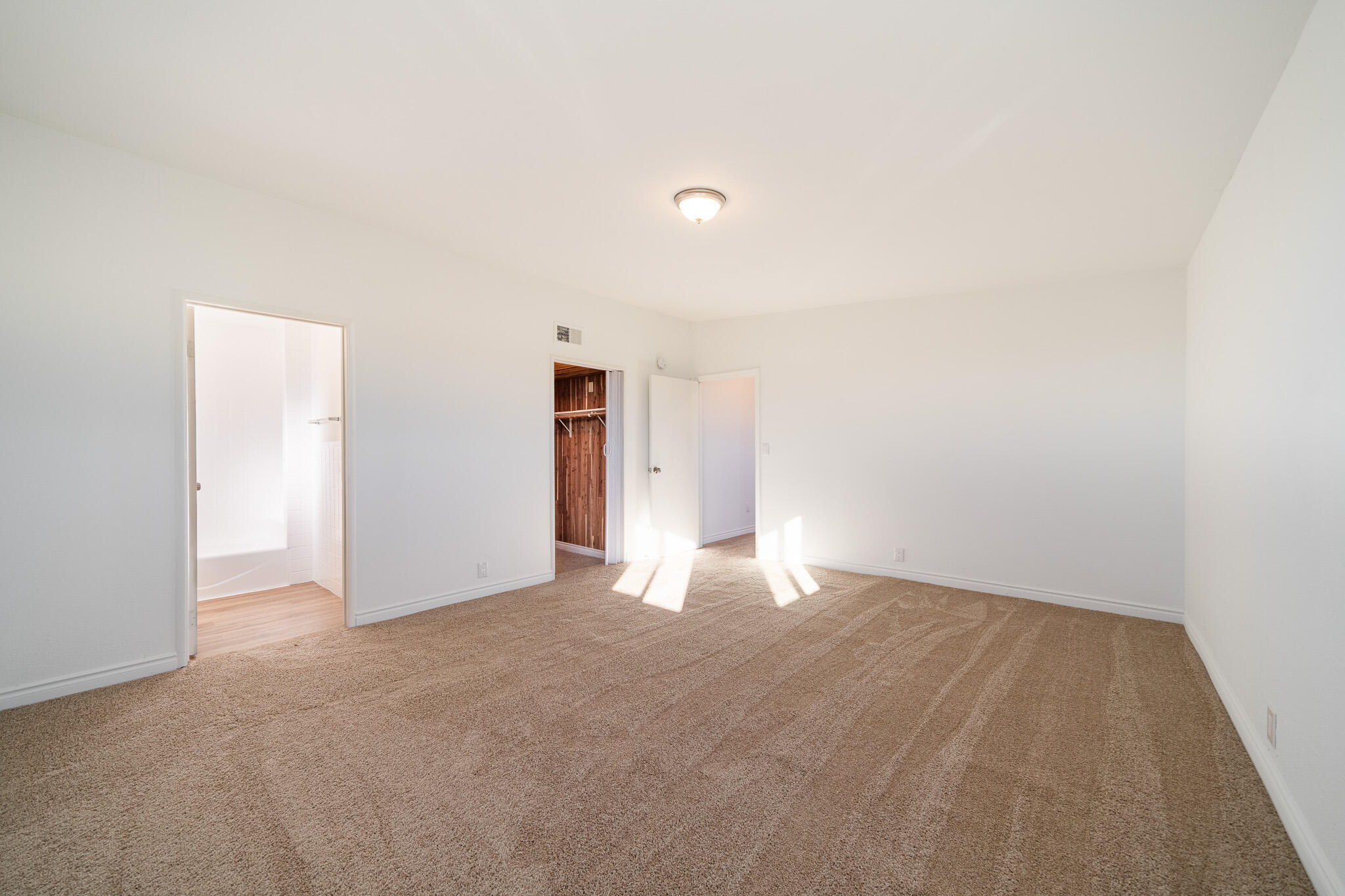 8443 Gaskell Road Rosamond, CA 93560 - Photo 32 of 45 a view of an empty room with wooden floor and a window